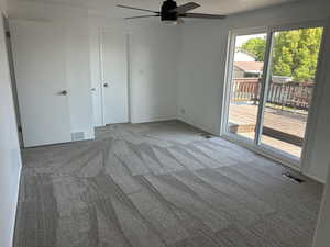Unfurnished bedroom featuring carpet flooring, access to exterior, and a ceiling fan