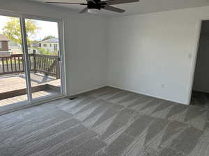 Carpeted spare room with ceiling fan and baseboards