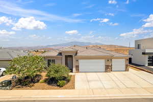 Prairie-style house with a mountain view, stucco siding, stone siding, and a tiled roof