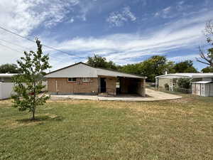 Back of property with a patio area and brick siding