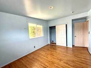 Unfurnished bedroom featuring light wood-style flooring and a closet