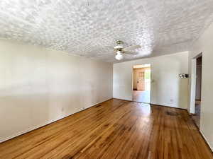 Spare room with hardwood / wood-style floors, ceiling fan, and a textured ceiling
