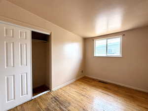 Unfurnished bedroom featuring wood-type flooring and a closet