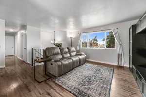 Living room with wood finished floors and a chandelier