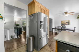 Kitchen featuring high end fridge, ceiling fan, dishwasher, and tile patterned floors