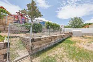 Fenced backyard featuring a vegetable garden