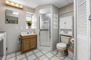 Full bath featuring vanity, a drop ceiling, a shower stall, tile patterned floors, and a closet