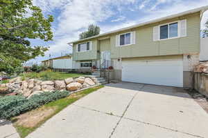 Split foyer home featuring a garage and concrete driveway