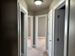 Hall featuring carpet flooring and baseboards
