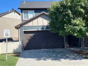 View of front of property featuring concrete driveway, an attached garage, board and batten siding, and stone siding
