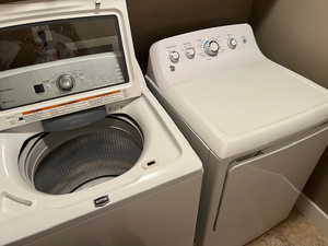 Laundry area with separate washer and dryer and tile patterned flooring
