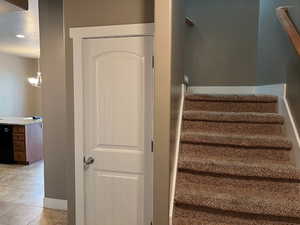Stairs featuring a textured ceiling, tile patterned floors, and recessed lighting