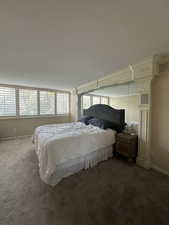 Carpeted bedroom with baseboards and decorative columns