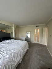 Bedroom featuring crown molding, carpet, french doors, and a textured ceiling