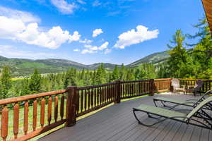 Deck featuring a mountain view and a tons of trees