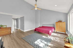 Bedroom with light wood-style floors, high vaulted ceiling, a ceiling fan, and recessed lighting