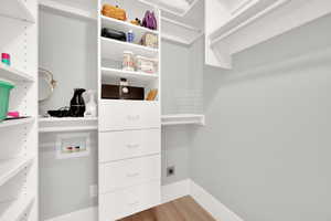 Walk in closet with wood finished floors
