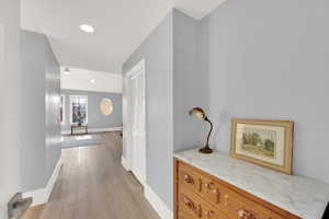 Corridor with light wood finished floors and recessed lighting