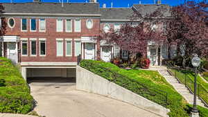 Townhome / multi-family property with brick siding, concrete driveway, and a garage