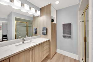 Bathroom with a shower stall, vanity, and wood finished floors