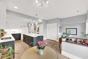 Dining room featuring light wood-style flooring, ceiling fan, and recessed lighting