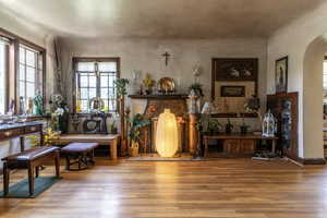 Sitting room featuring arched walkways and wood finished floors