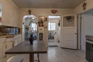 Kitchen featuring light tile patterned flooring and arched walkways