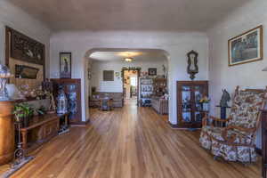 Living area with arched walkways and wood-finished floors
