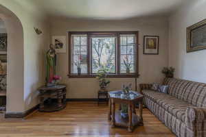 Living room with arched walkways and wood finished floors
