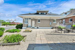 Back of house with an outdoor fire pit, brick siding, a vegetable garden, and a patio area