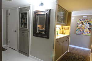 Hallway with a sink and baseboards