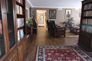 Living room with dark wood-style floors and crown molding
