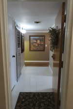 Hall featuring tile patterned floors and crown molding