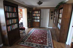 Foyer entrance with wood finished floors and ornamental molding