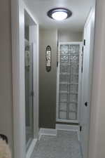 Hallway featuring tile patterned flooring and baseboards