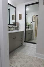 Bathroom featuring vanity and tasteful backsplash