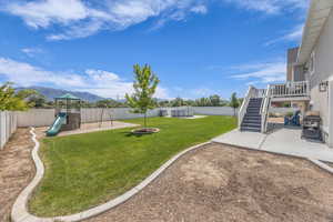 Fully fenced backyard with patio and playground set