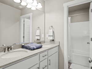 Full bathroom with double vanity and shower / bath combo with shower curtain