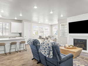 Living area with light wood-style floors, recessed lighting, a fireplace, and a textured ceiling