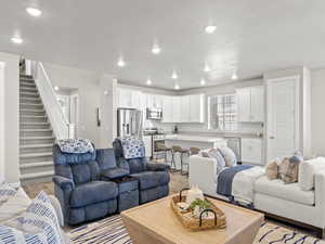 Living area with light wood-style flooring, stairway, and recessed lighting
