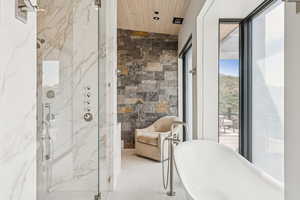 Full bathroom with a marble finish shower, a freestanding bath, and wood ceiling