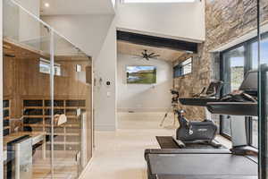 Workout room with ceiling fan, high vaulted ceiling, and a relaxing sauna