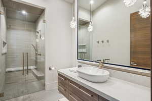 Bathroom featuring vanity, a stall shower, tile patterned floors, a chandelier, and recessed lighting