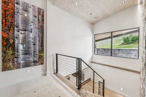 Stairway with recessed lighting and wooden ceiling