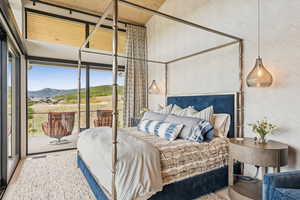 Bedroom with wallpapered walls, a mountain view, access to outside, wood finished floors, and floor to ceiling windows