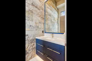 Bathroom featuring vanity and tile walls