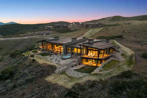 Back of house featuring a patio, a chimney, a mountain view, and a metal roof