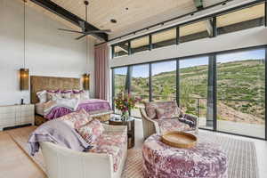 Bedroom featuring a towering ceiling, access to exterior, a wood ceiling with exposed beams, and tile patterned flooring