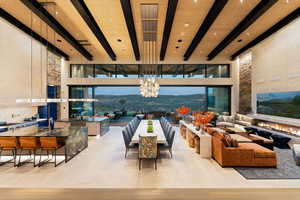 Living room featuring beam ceiling, a mountain view, a high ceiling, a chandelier, and healthy amount of natural light