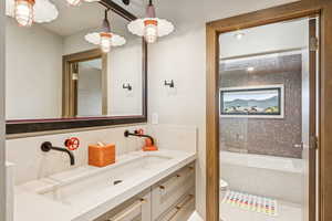 Bathroom featuring tasteful backsplash, vanity, and a tub to relax in
